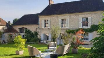 A stone house with a well-maintained lawn and outdoor seating area.