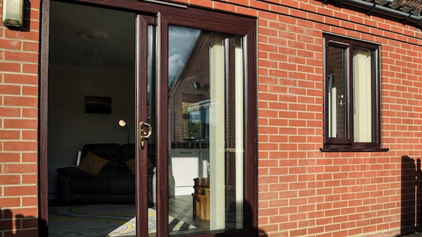 A red brick house with a sliding glass door leading to a living room with a sofa and a coffee table. - Keepers Retreat, The Annex (Roughton)