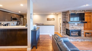 A modern kitchen with dark wood cabinets, a central island, and a built-in microwave.