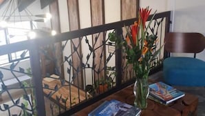 Een moderne woonkamer met een houten salontafel, een blauwe bank en een trap met decoratief hekwerk.