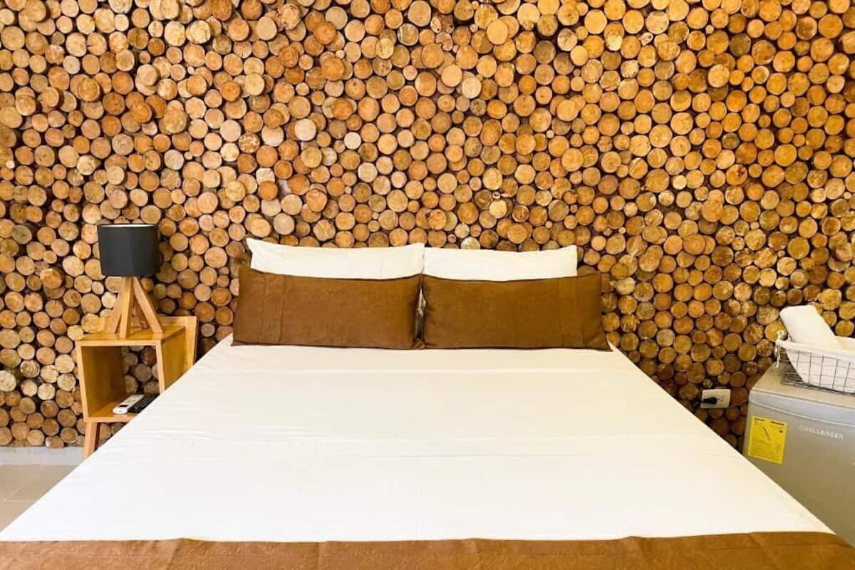 A bed with white bedding, two brown pillows, and a wooden headboard.