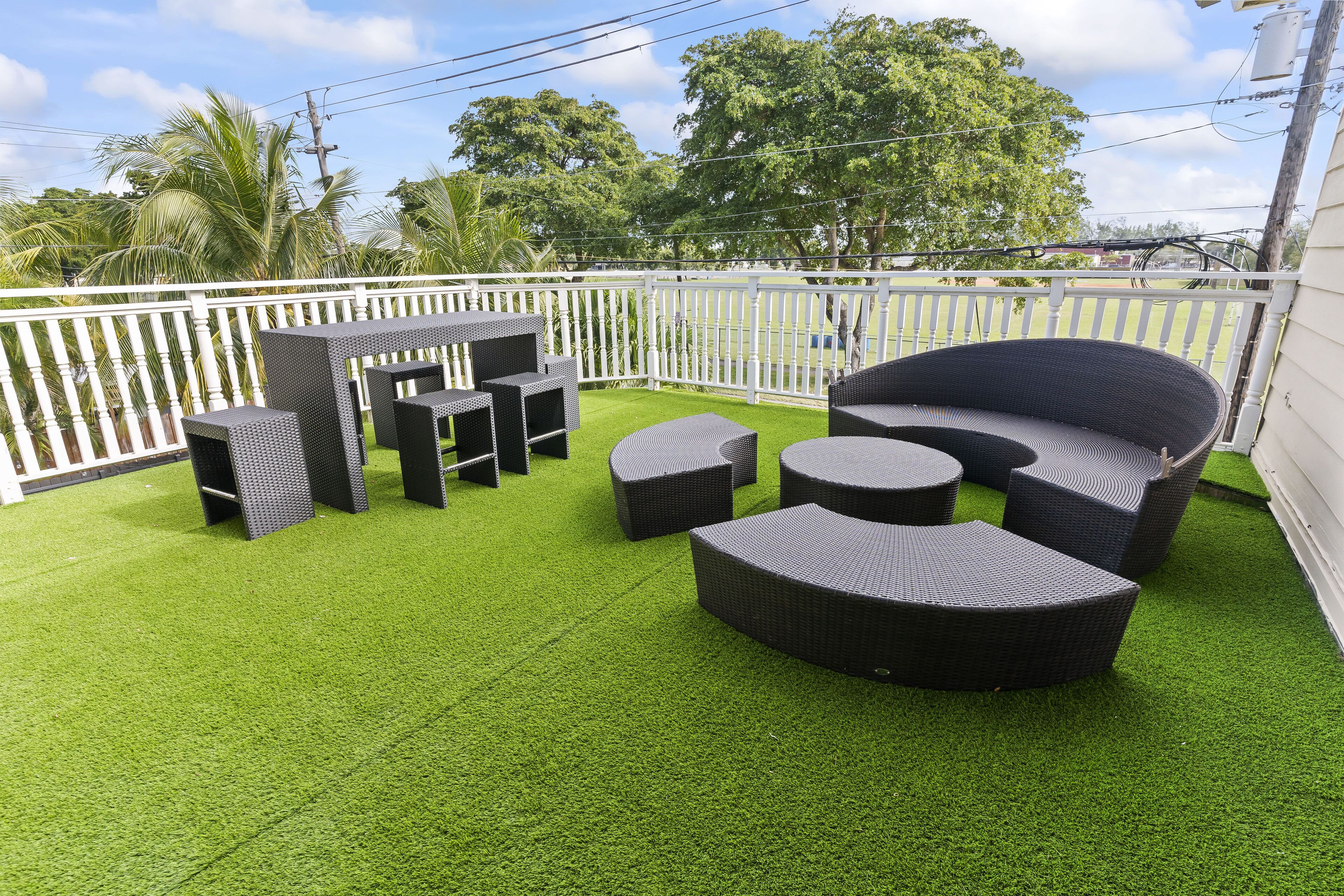 A patio with outdoor furniture, including sofas and tables, on artificial grass.