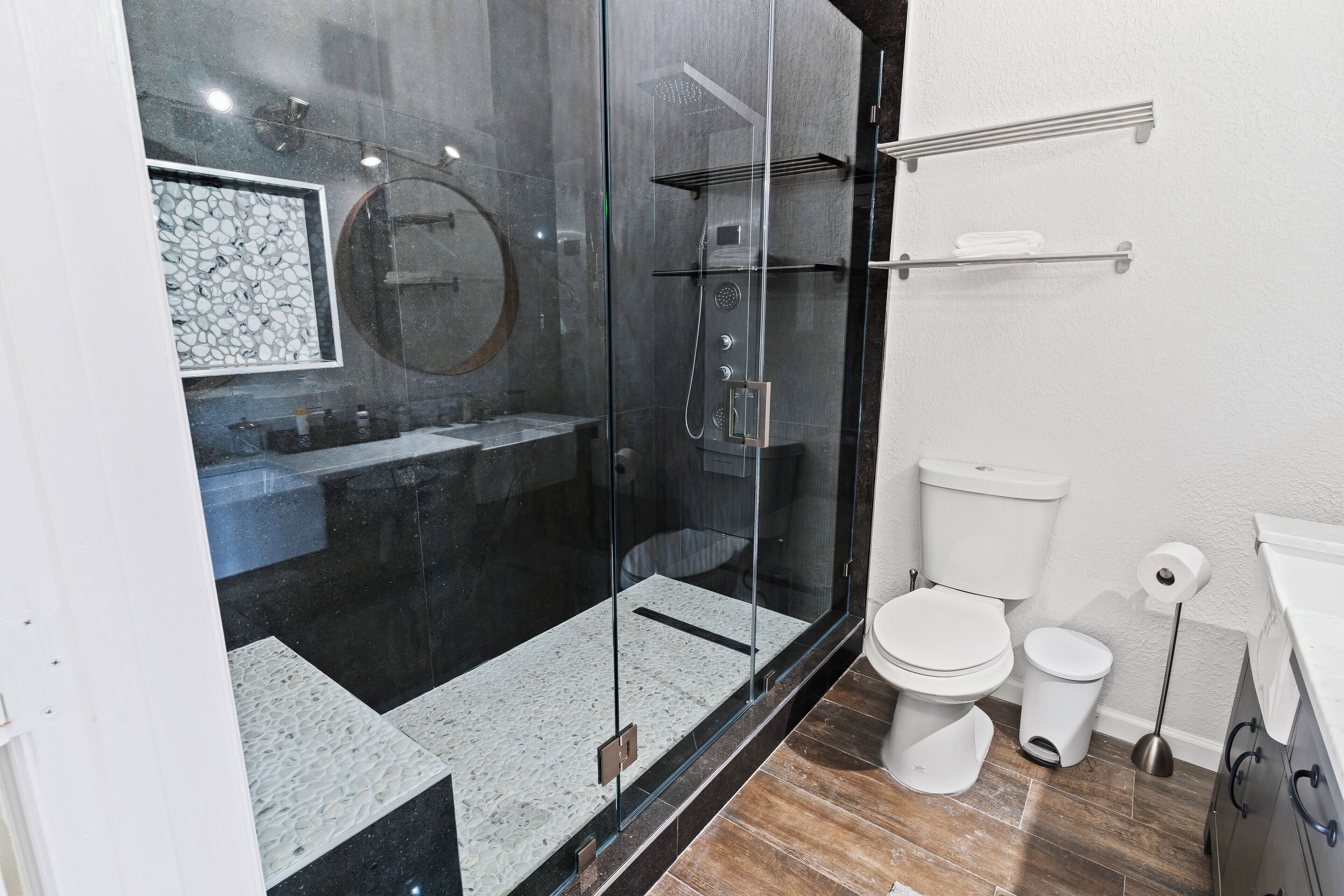 Une salle de bain moderne avec une douche à parois de verre, des toilettes et un lavabo.