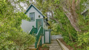 A house with a green exterior, a wooden deck, and a covered porch area. - Tranquil Family Home located in Surfman's Walk; private crofter with shoals access (Bald Head Island)