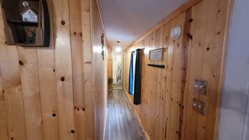 A wooden hallway with a sign reading "GUEST" and a small shelf with a decorative item.