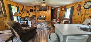 Ein Ferienhaus-Innenraum mit Wohnbereich, Esstisch und einer Küchenzeile.