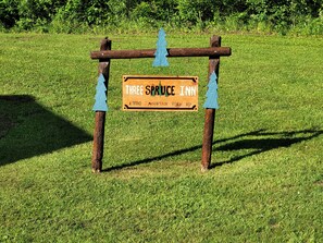 A wooden sign for the Three Spruce Inn, indicating its location at Mountain View Rd.