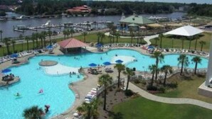 Ein Resort mit mehreren Schwimmbecken, einer Marina und einem großen Wasserturm im Hintergrund.