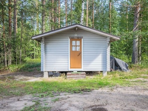 A small, single-story cabin with a wooden door and a small porch, surrounded by a forested area. - Mäntyranta by Interhome (Savonlinna)