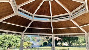A gazebo with a wooden roof and white columns, surrounded by a fenced garden with trees and a fountain. - 3bd, 2bth, 1K&2Q, Walk to park! Park 1 car in Ga.! (St. Louis)