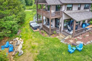 A two-story house with a deck, outdoor seating, and a hot tub. - Maynard Rocks IV at Elk Creek - Hot tub, creekside setting, firepit (Banner Elk)