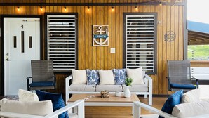 A covered outdoor seating area with wooden flooring, white furniture, and a ceiling fan. - Casa Garito La Parguera - Home for up to 24 guests (La Parguera)