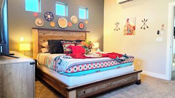 Een slaapkamer met een houten bed, een televisie, een lamp en decoratieve wandaccessoires.