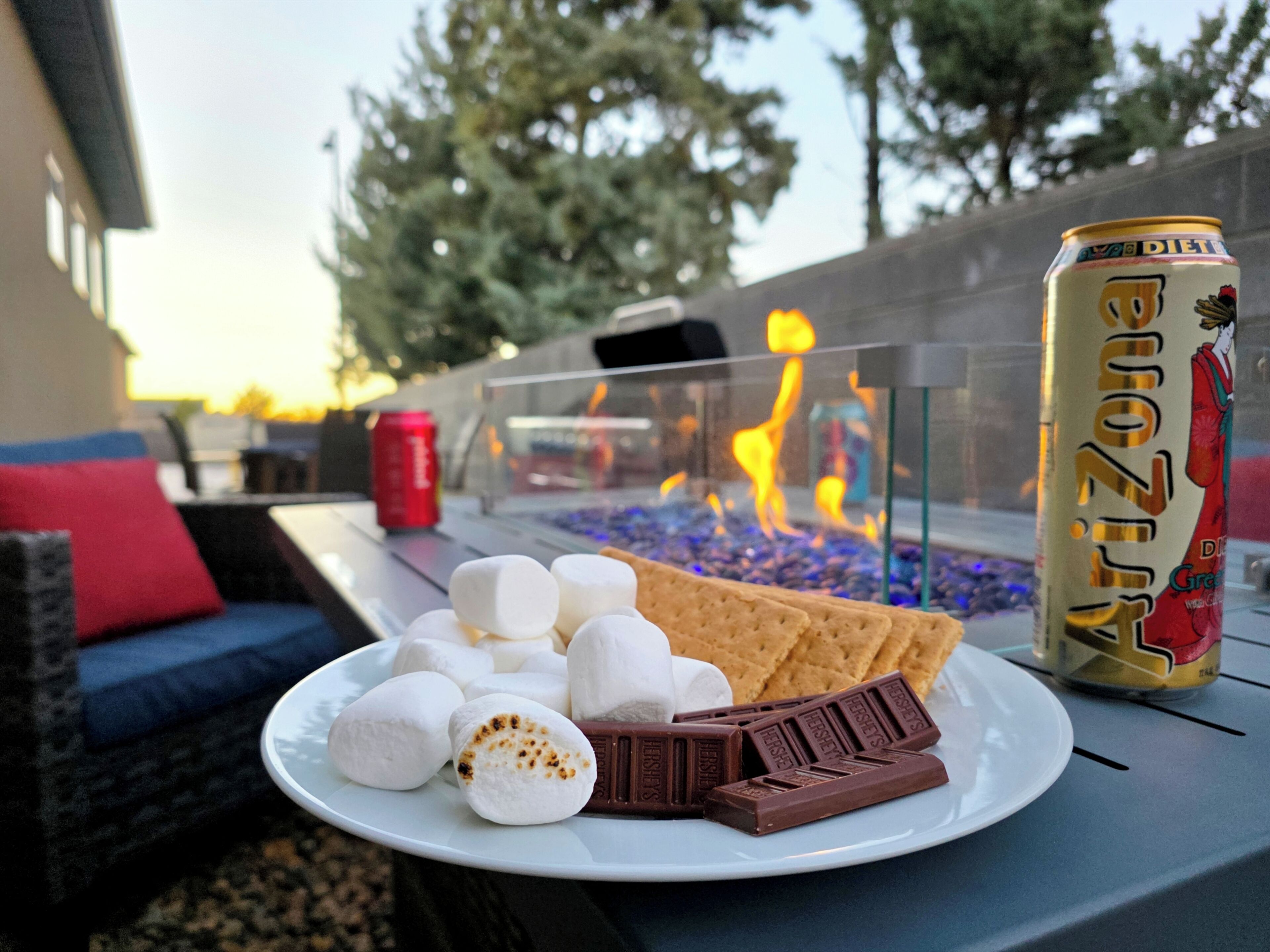 A plate with marshmallows, chocolate, and crackers on a table with a can of Arizona Diet Coke.