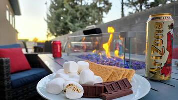A plate with marshmallows, chocolate, and crackers on a table with a can of Arizona Diet Coke.