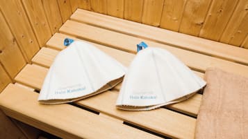 Two towels with text on them placed on a wooden bench.