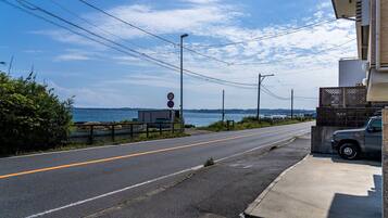 Uma estrada costeira com placa de limite de velocidade, um caminhão estacionado e vista para o mar.