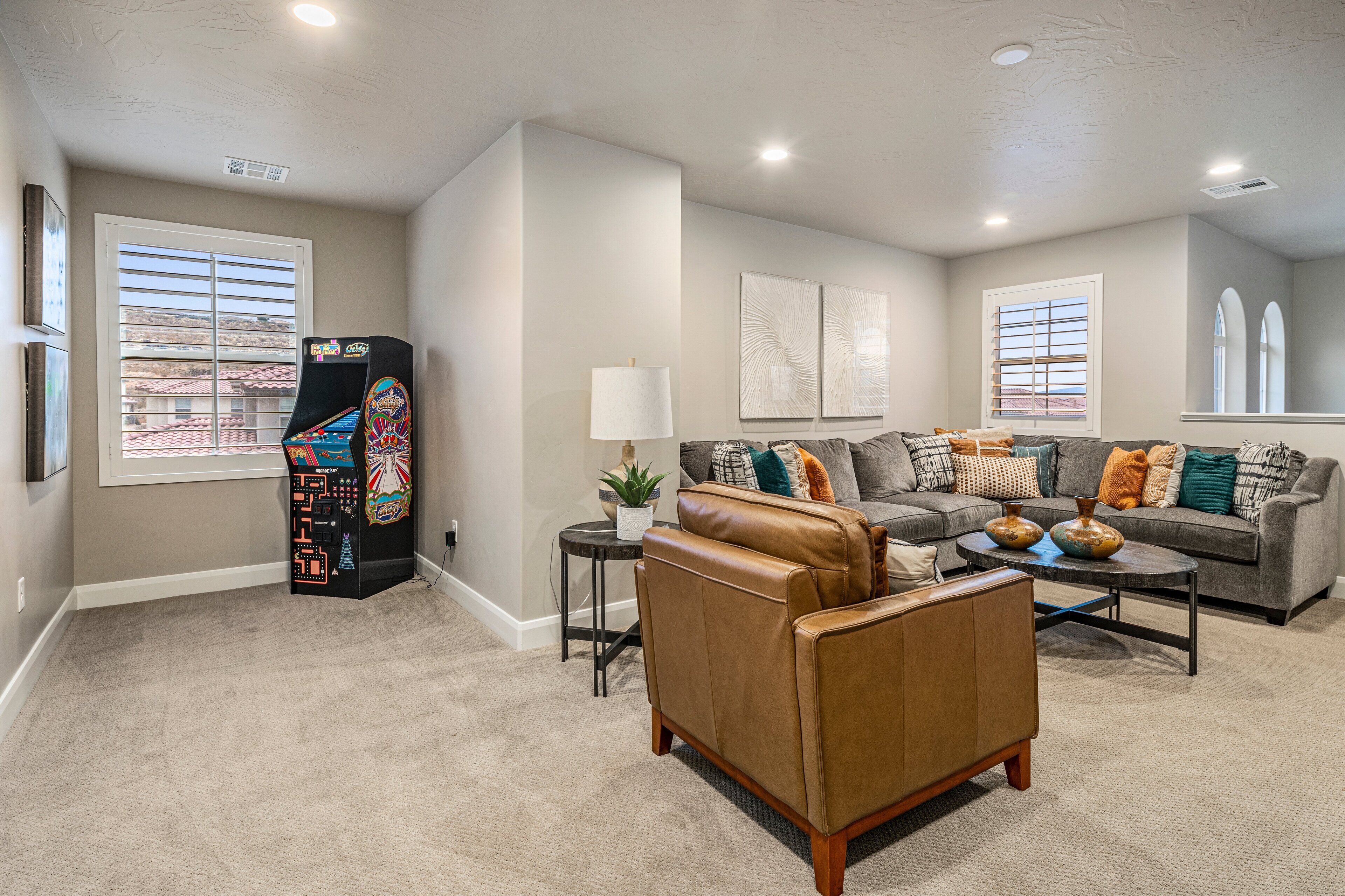 A living room with a sofa, coffee table, and a gaming console.