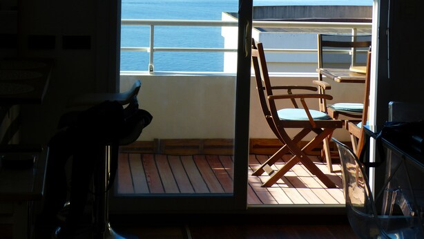 A room with a sliding glass door leading to a balcony overlooking the sea. - Sea view luxury residence (Corse)