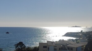 A coastal view with a clear sky, calm sea, and buildings in the foreground. - Sea view luxury residence (Corse)