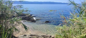 A coastal landscape with clear water, rocky shoreline, and vegetation. - Luxury Residence with Ocean Views (Corse)