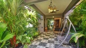 Une pièce avec un sol à carreaux, un ventilateur de plafond et diverses plantes.