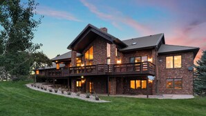 A large, multi-story brick house with a balcony, large windows, and a well-maintained lawn. - Gorgeous Estate Home on 186 Acre Ranch only minutes from Colorado Springs or AFA (Colorado Springs)