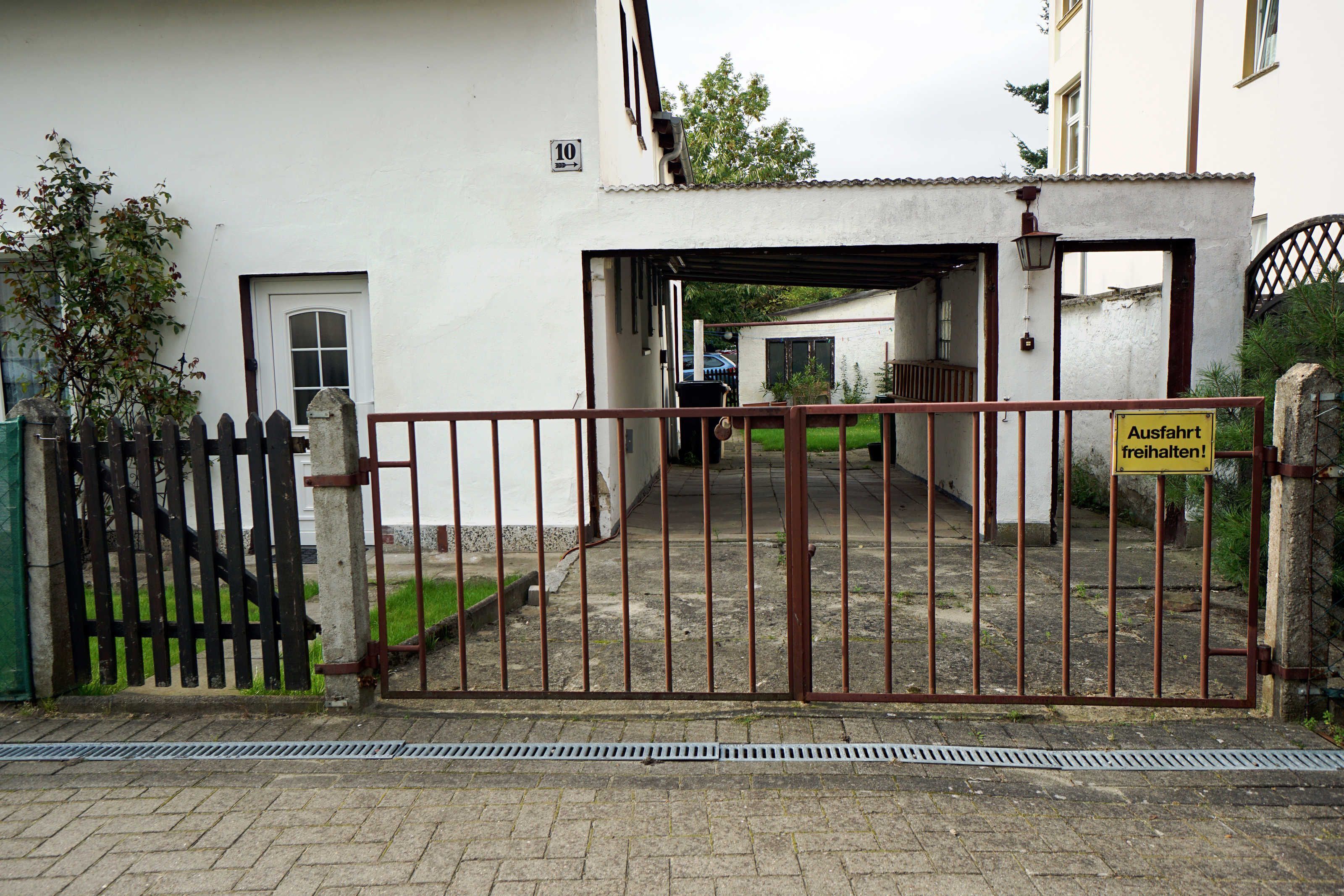 A gated entrance to a building with a sign indicating a parking area.