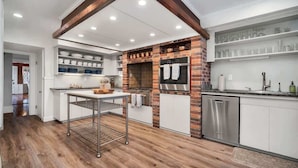 A modern kitchen with a brick backsplash, stainless steel appliances, and a central island. - Magnificent Ferncrest - Towering Home on the Coast (Groton)