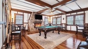 A spacious room with a pool table, stone fireplace, and wooden ceiling beams. - Magnificent Ferncrest - Towering Home on the Coast (Groton)