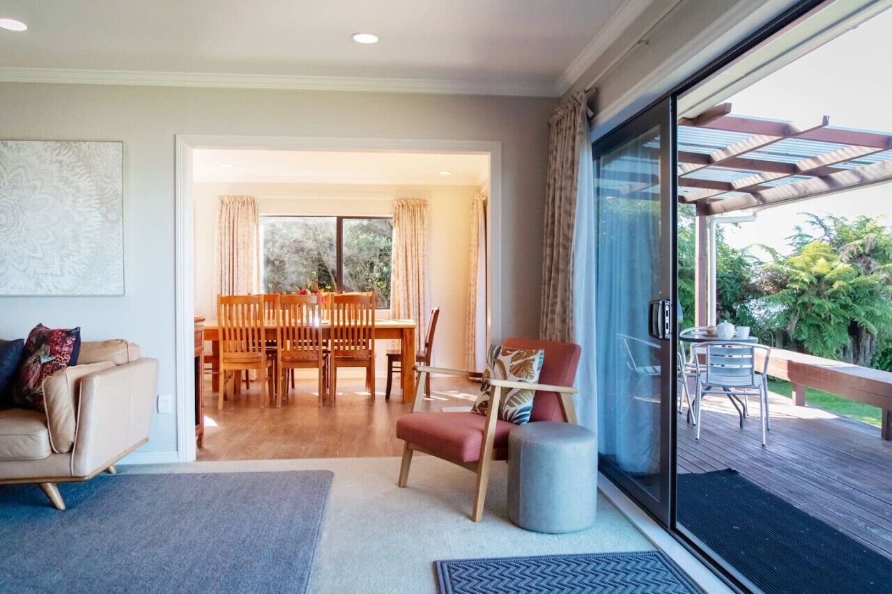 A spacious living room with a large sliding glass door leading to an outdoor deck.
