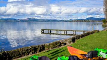 A lakeside view with kayaks and a wooden dock.