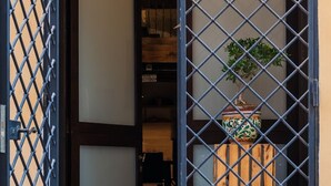 A traditional Japanese-style room with tatami flooring, a shoji screen door, and a potted plant.