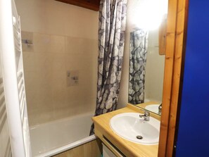 A bathroom with a bathtub, a sink, and a mirror. - Sunny Duplex Apartment, Sleeps 5, Pool, Near Shops & Slopes (Arêches-Beaufort)