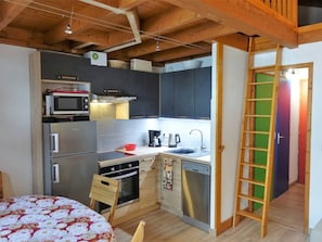 Una cocina compacta equipada con microondas, refrigerador, estufa y lavavajillas.