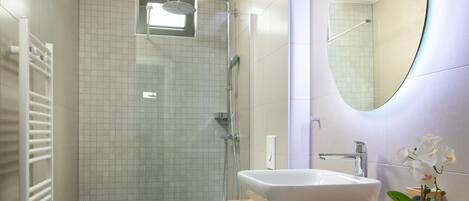 Un baño moderno con una bañera independiente, un inodoro y una ducha.