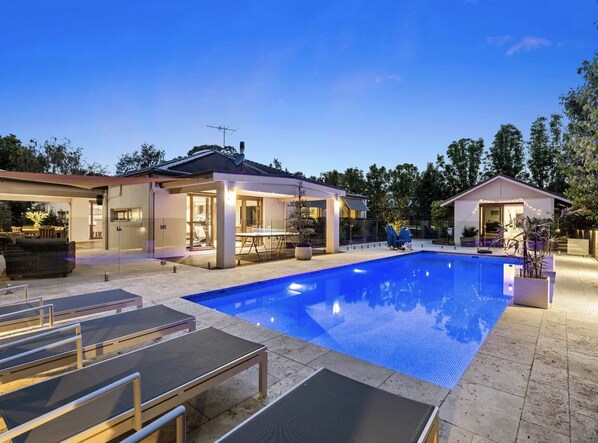A swimming pool with lounge chairs and a covered patio area. - Luxury Home with Pool. Only 4 min walk to Mount Martha Beach (Mount Martha)