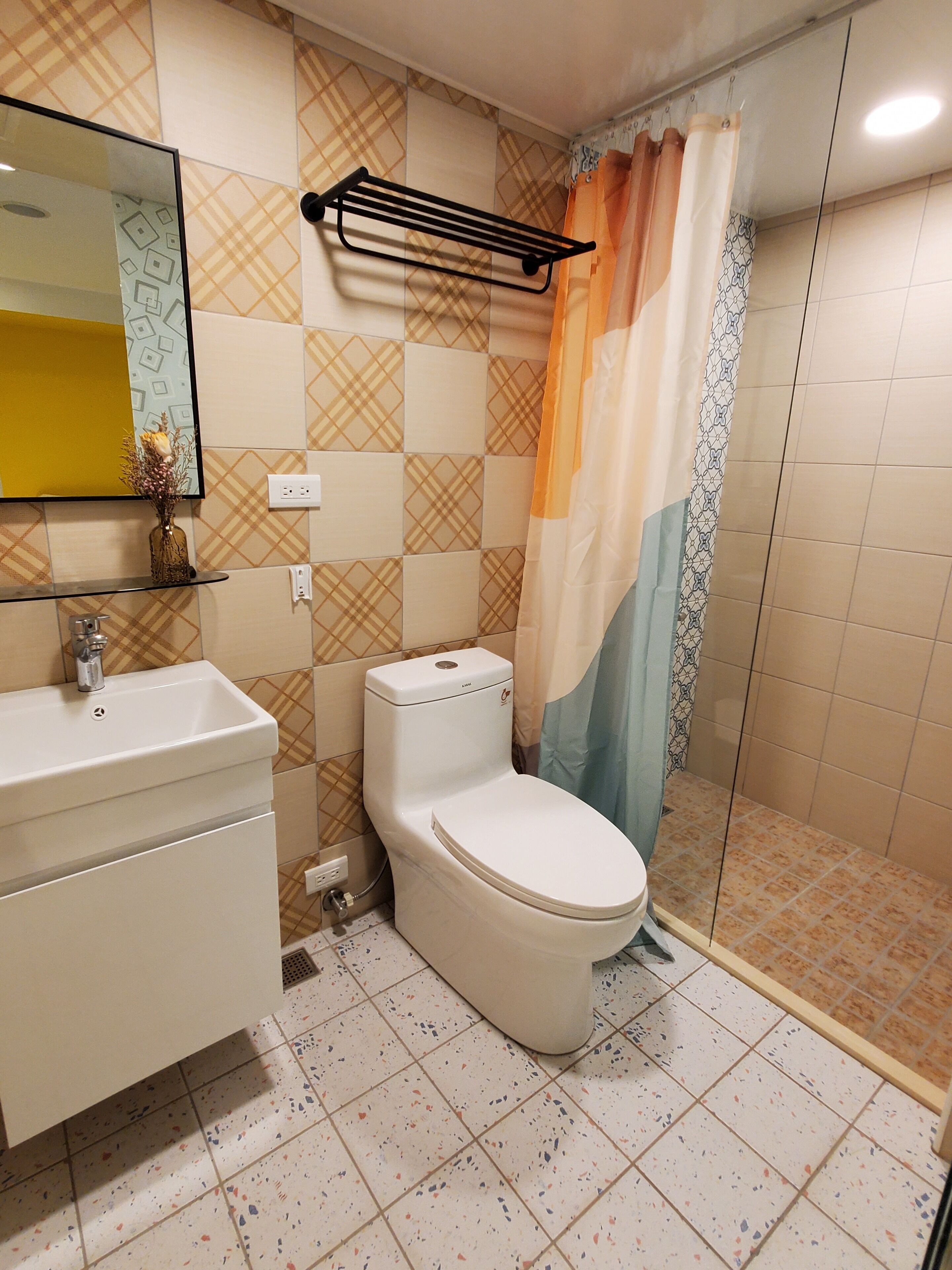 Un baño con inodoro, lavamanos y zona de ducha.