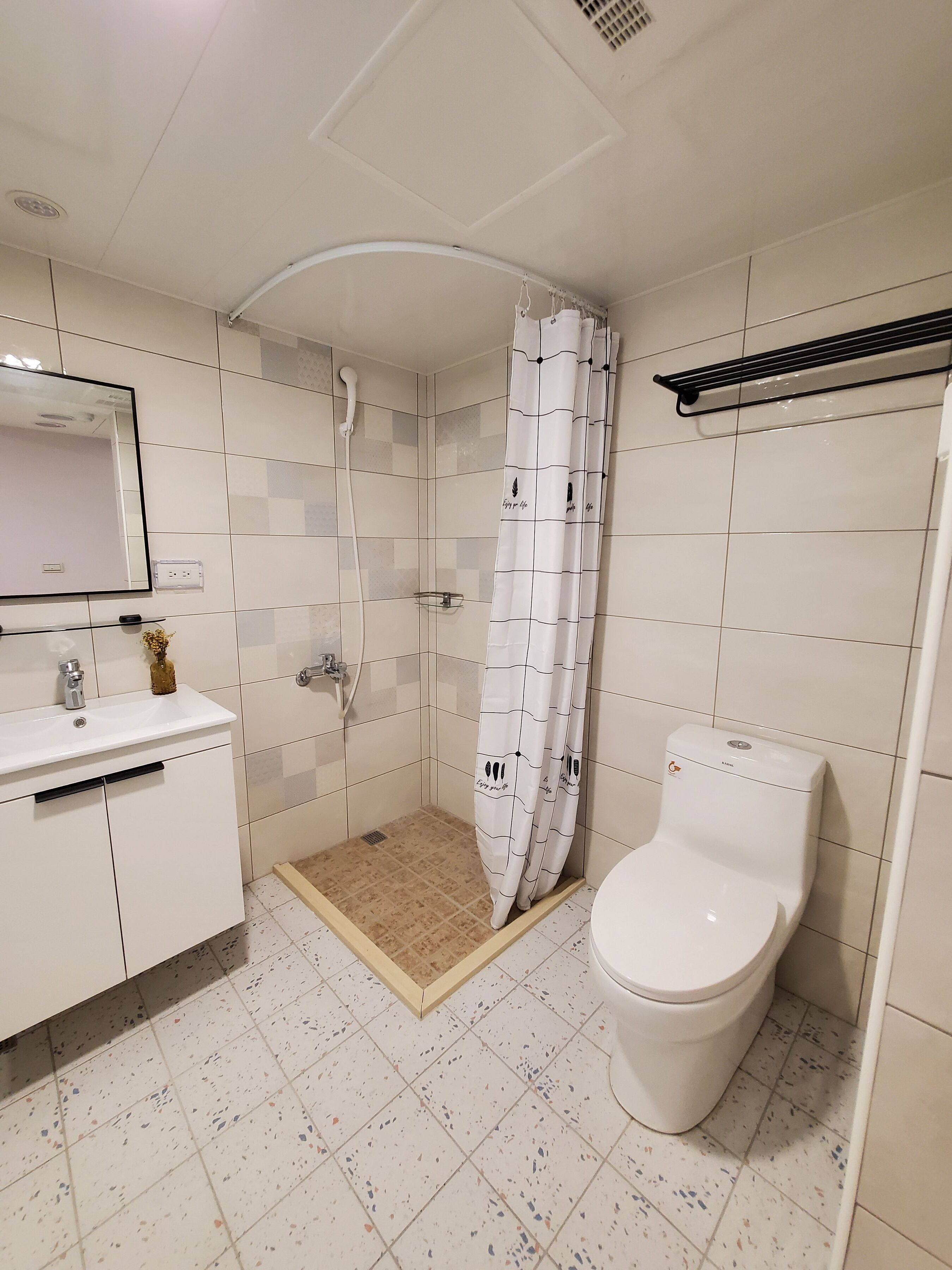 Un baño moderno con ducha, inodoro y lavamanos.