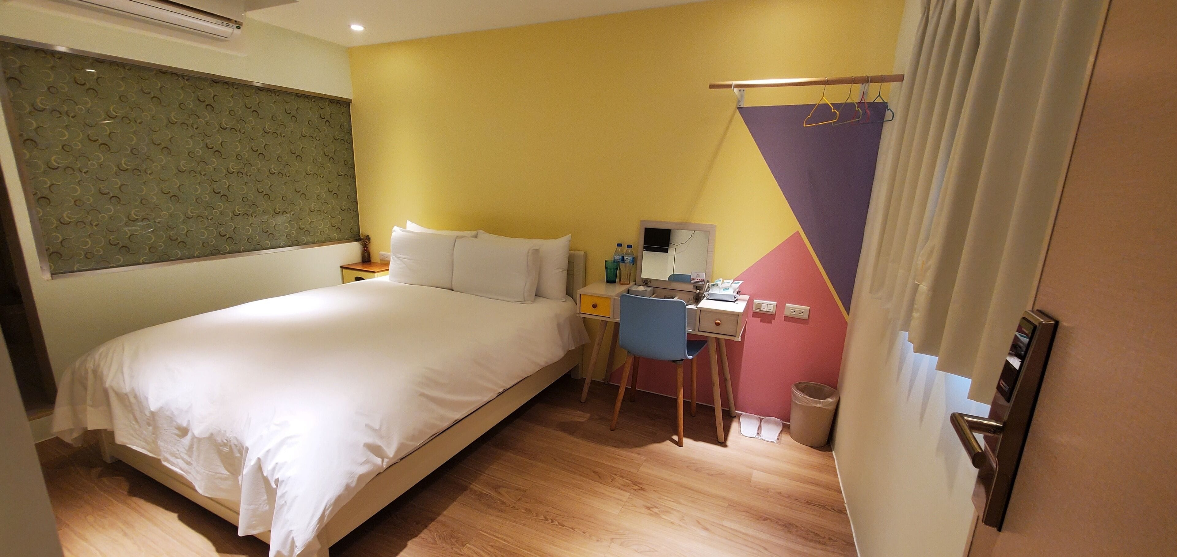 Een hotelkamer met een bed, een bureau en een stoel.