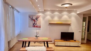Uma sala de estar moderna com uma mesa de madeira, um banco e um suporte para TV.
