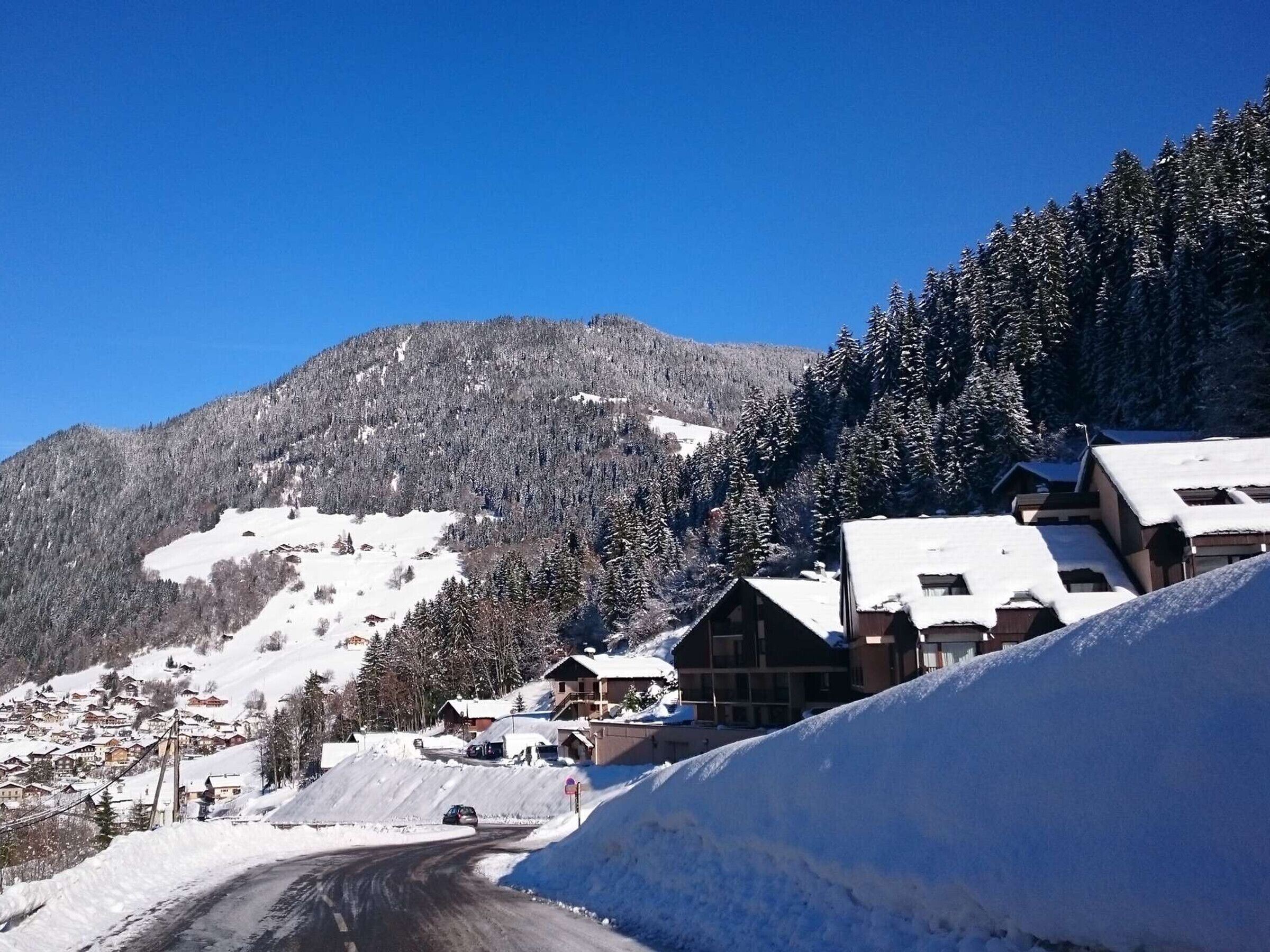 A snow-covered mountain village with buildings and a road.