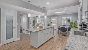 A modern kitchen with a central island, wooden flooring, and pendant lighting. - 4 Min 2 Nightlife l HUGE Cabana l Pool & Spa l Golf l BBQ
 (Scottsdale)