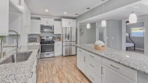 A modern kitchen with granite countertops, stainless steel appliances, and white cabinetry. - 4 Min 2 Nightlife l HUGE Cabana l Pool & Spa l Golf l BBQ
 (Scottsdale)