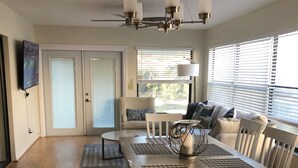 A spacious dining area with a long table, white chairs, and a ceiling fan. - Beautiful Spacious 3 bedroom home near Clearwater Beach, Pet friendly! (Clearwater)