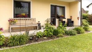 Ein Haus mit Veranda, einer Bank und Topfpflanzen.