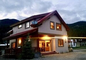 Situated in a serene natural setting, this two-story home offers a charming front porch with a railing.
