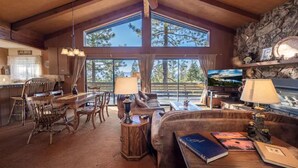 A spacious living room with a large wooden dining table, comfortable seating, and a stone fireplace. - ❤❤❤Tahoe Vacation Stay w/Lake Views/Next to Casinos❤❤❤ (Stateline)