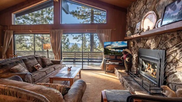 A cozy living room with a stone fireplace, large windows, and a television. - ❤❤❤Tahoe Vacation Stay w/Lake Views/Next to Casinos❤❤❤ (Stateline)