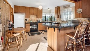 A kitchen with wooden cabinets, a central island, and a dining area with chairs. - ❤❤❤Tahoe Vacation Stay w/Lake Views/Next to Casinos❤❤❤ (Stateline)